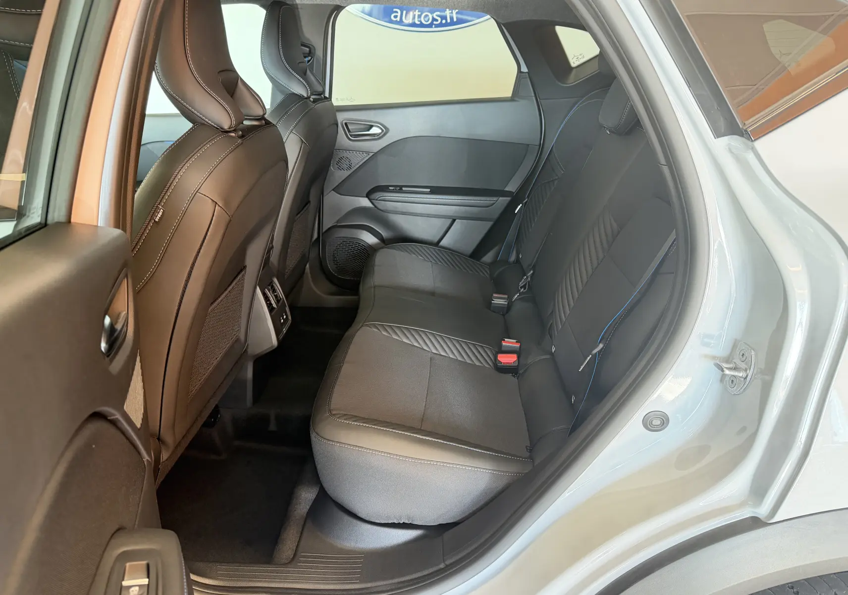 Vue intérieure côté droit des sièges arrière noirs avec surpiqûres bleues du Renault Captur E-Tech 160 Esprit Alpine gris Rafale.