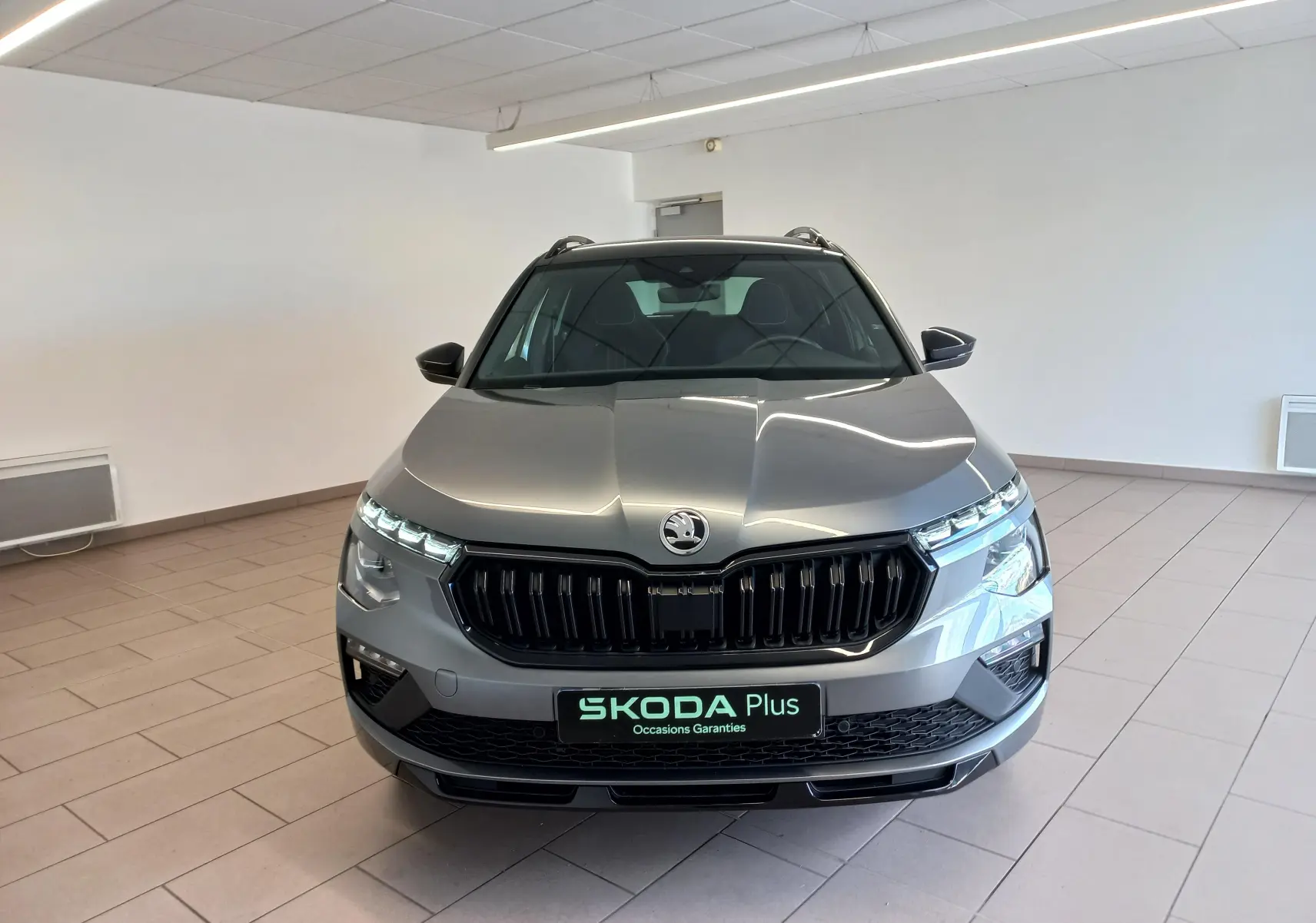 Vue frontale d'un Skoda Kamiq 1.5 TSI 150 DSG7 Monte Carlo gris graphite, avec calandre noire et phares LED fins.