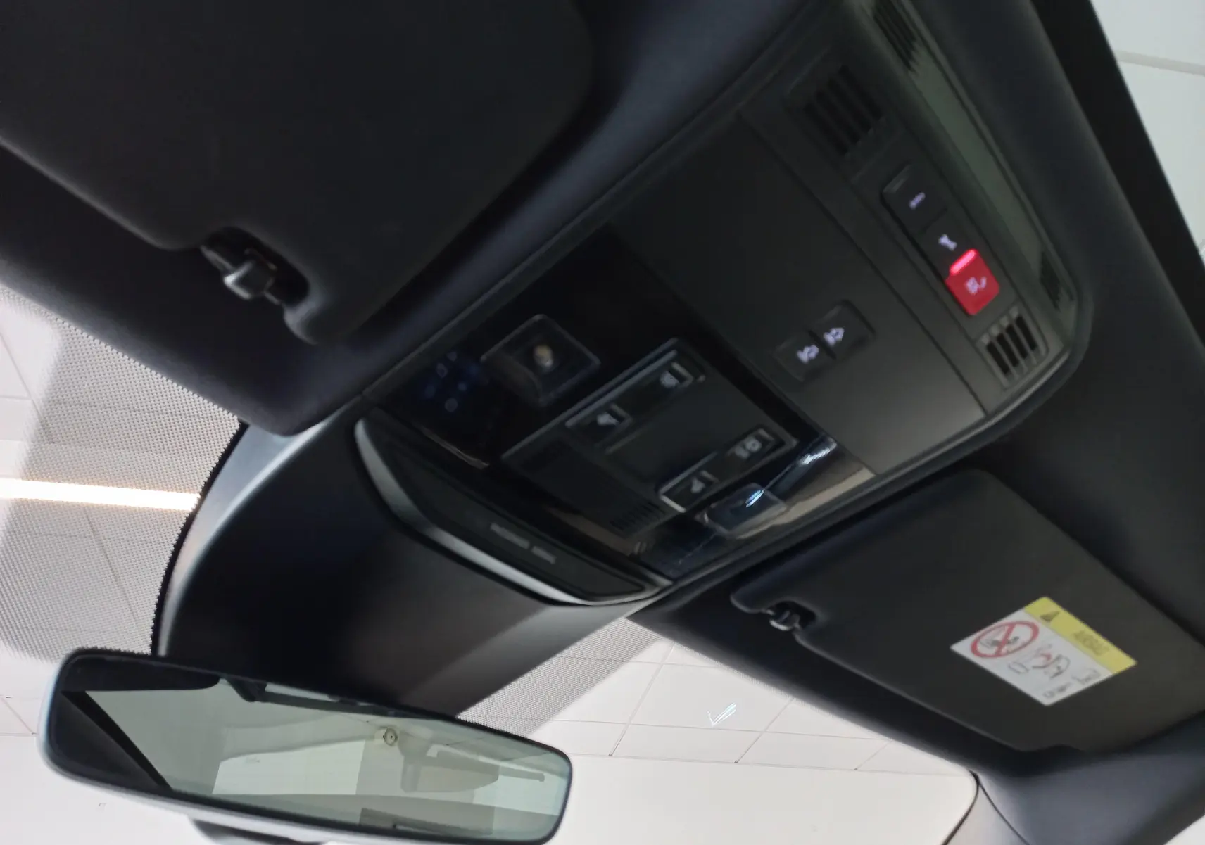 Vue intérieure du plafond avant du Skoda Kamiq 2024 gris graphite, montrant les commandes d’éclairage et le rétroviseur central.