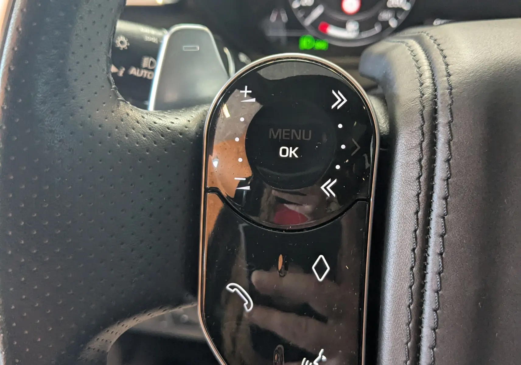 Gros plan sur les commandes tactiles noires du volant côté gauche du Range Rover Velar noir avec tableau de bord numérique.