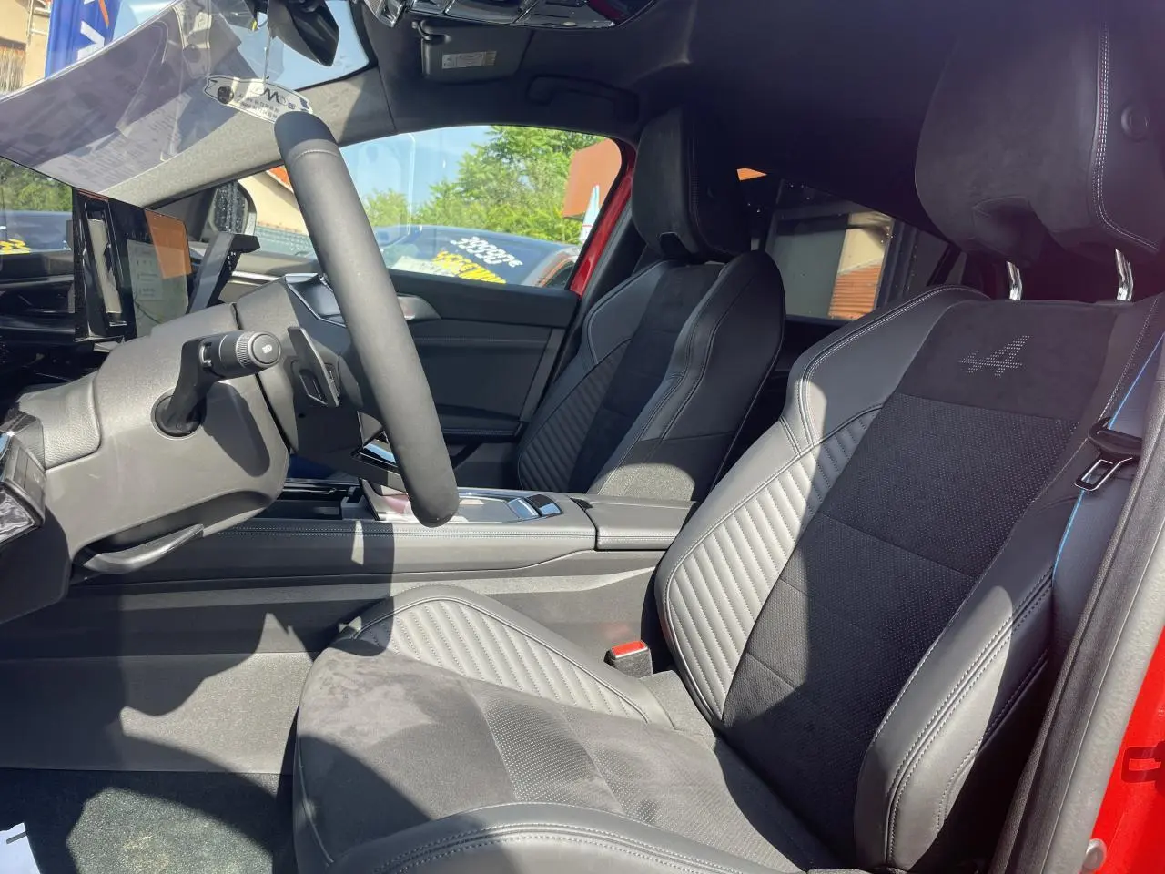 Intérieur côté conducteur de la Renault Rafale rouge, sièges sport Alcantara avec logo Alpine brodé sur appuie-tête.