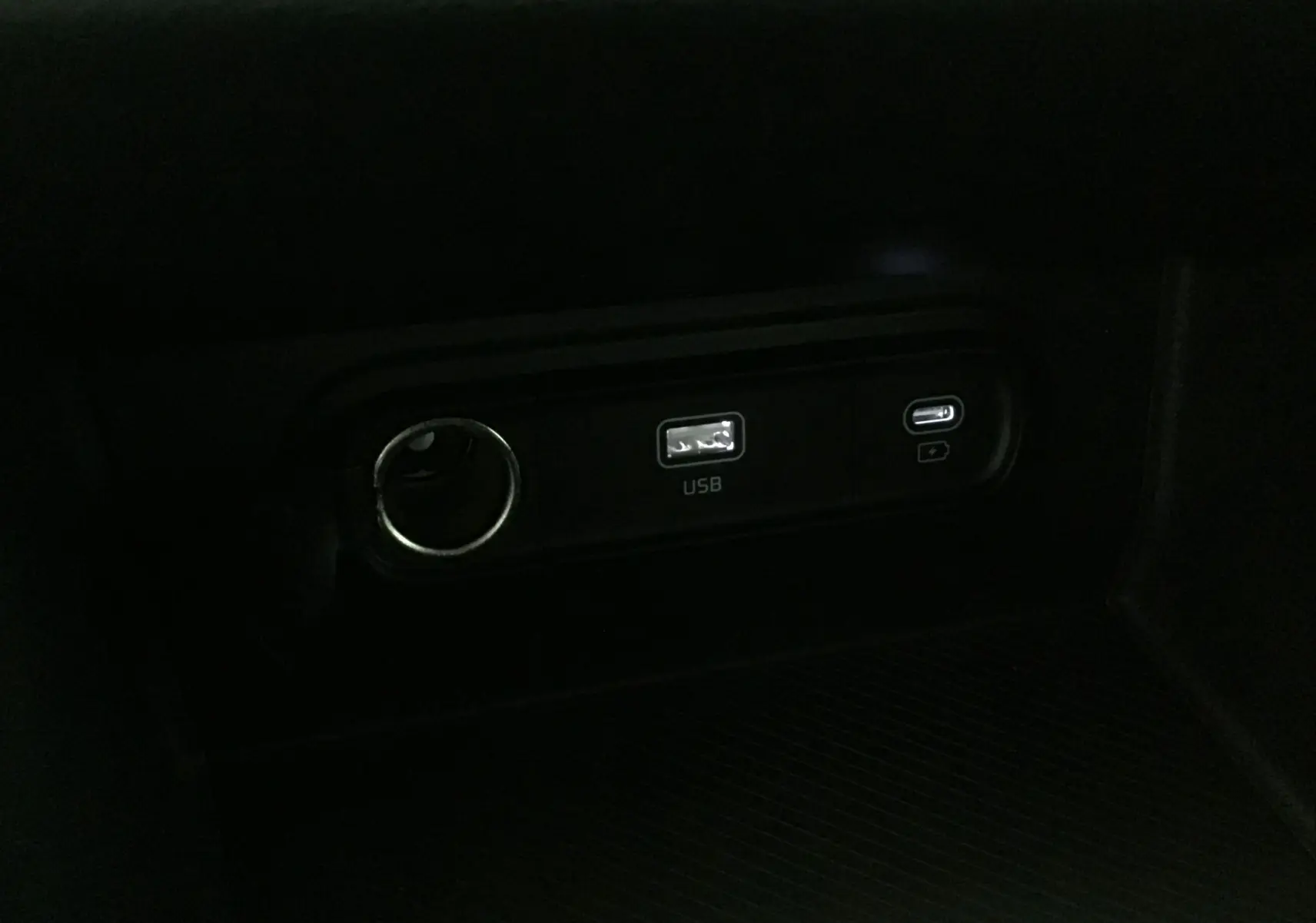 Prise USB et port USB-C intégrés dans la console centrale d'un Kia Sportage blanc 2025, version Style.