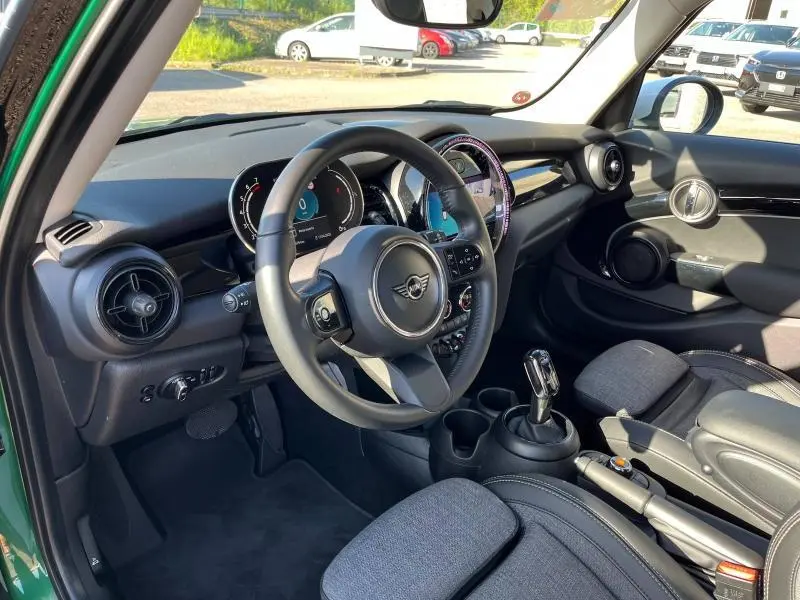 Intérieur avant droit d'une MINI Cooper S 2021 British Racing Green, volant cuir et tableau de bord numérique.