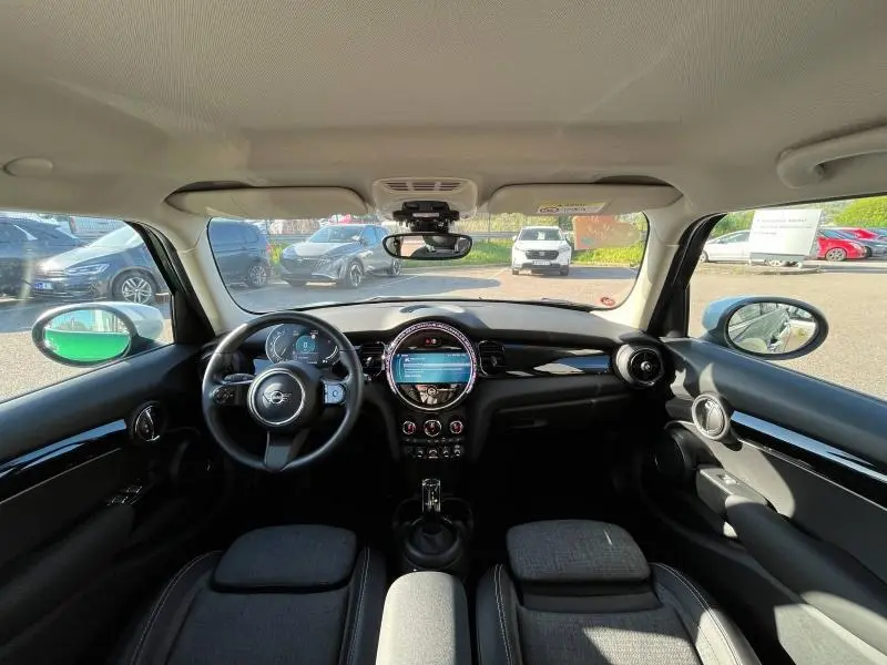 Vue intérieure avant de la MINI Cooper S 2021 avec tableau de bord noir et écran tactile central lumineux.
