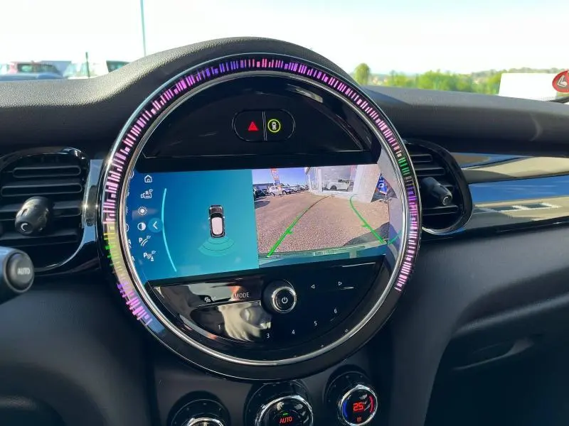 Vue rapprochée de l'écran central rond du tableau de bord MINI affichant la caméra de recul et l'aide au stationnement.