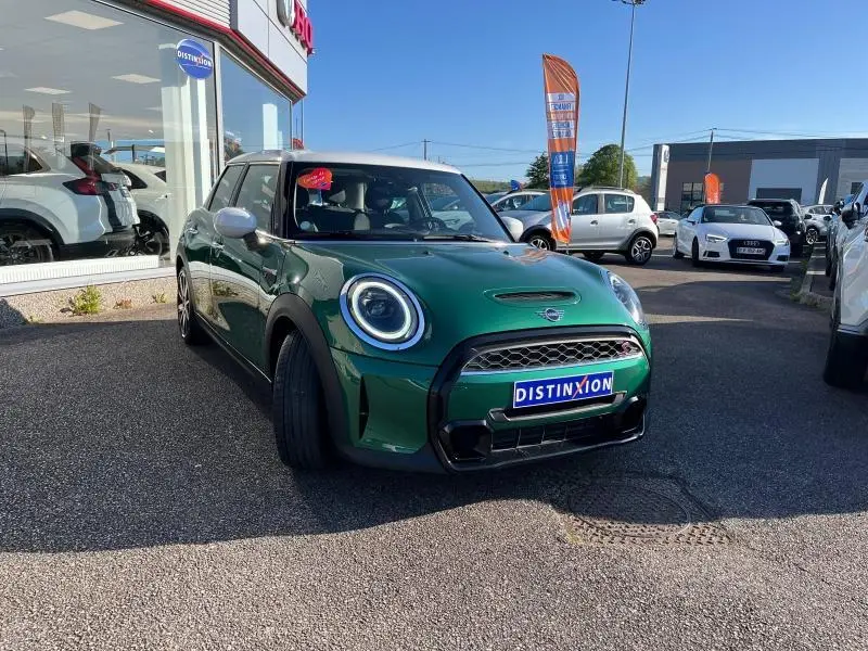 Vue 3/4 avant d'une MINI Cooper S 2021 British Racing Green avec toit blanc et jantes 17 pouces Roulette Spoke.
