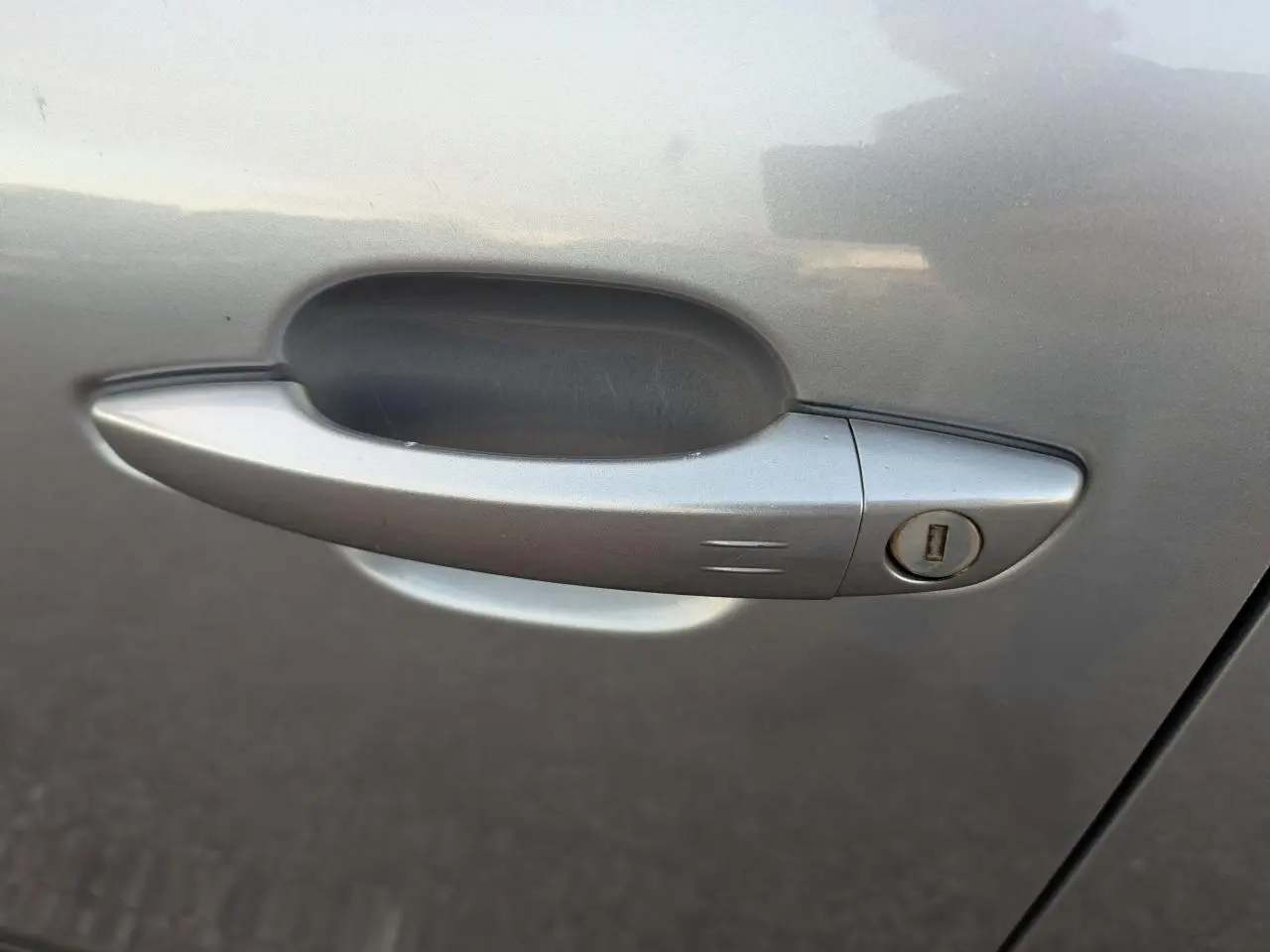 Poignée de porte côté gauche gris métallisé d'une Citroën C4 2022 avec serrure intégrée.