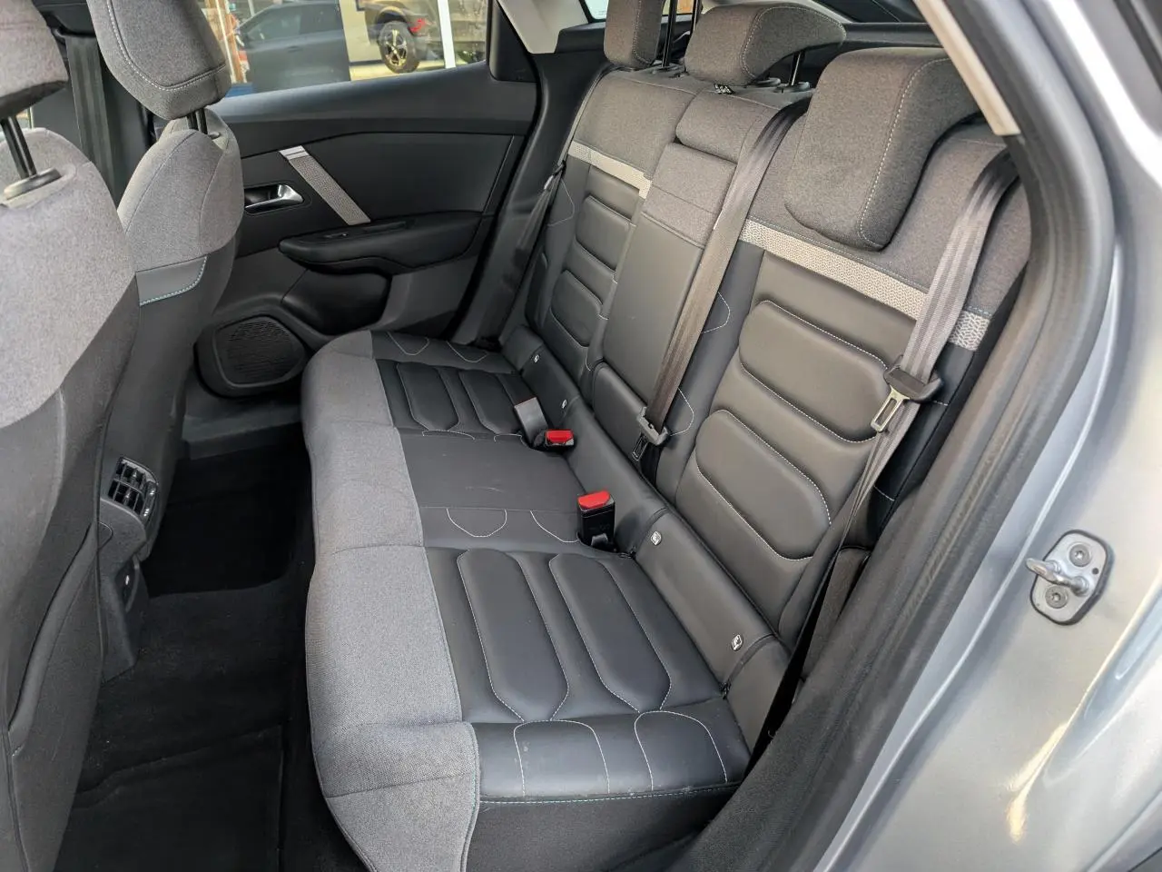 Vue côté droit sur la banquette arrière bi-matière cuir noir et tissu gris d'une Citroën C4 gris métallisé 2022.