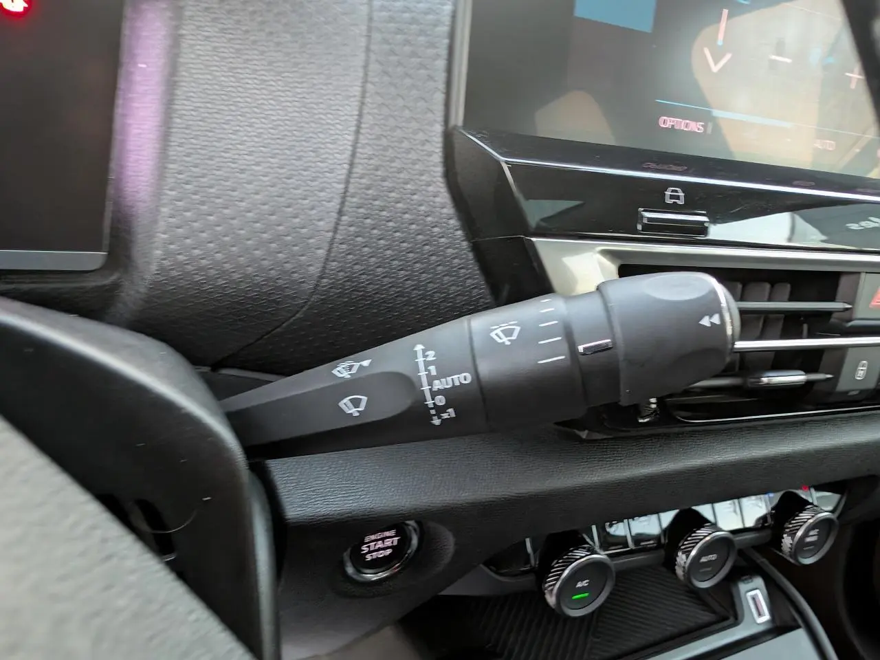 Gros plan sur la commande d’essuie-glace côté gauche du tableau de bord noir de la Citroën C4 gris métallisé.