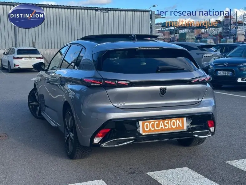 Vue 3/4 arrière d'une Peugeot 308 gris Artense avec feux arrière LED et jantes alliage noires.