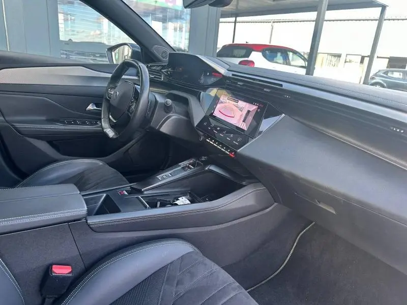 Vue intérieure côté conducteur de la Peugeot 308 gris Artense, avec tableau de bord moderne et écran tactile central.