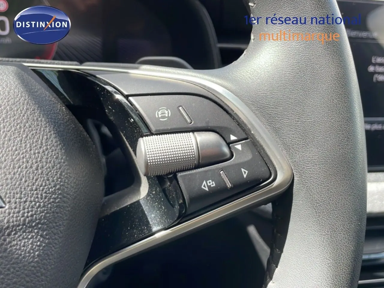 Gros plan sur les commandes multifonctions à droite du volant gris d’une Skoda Scala 2025.