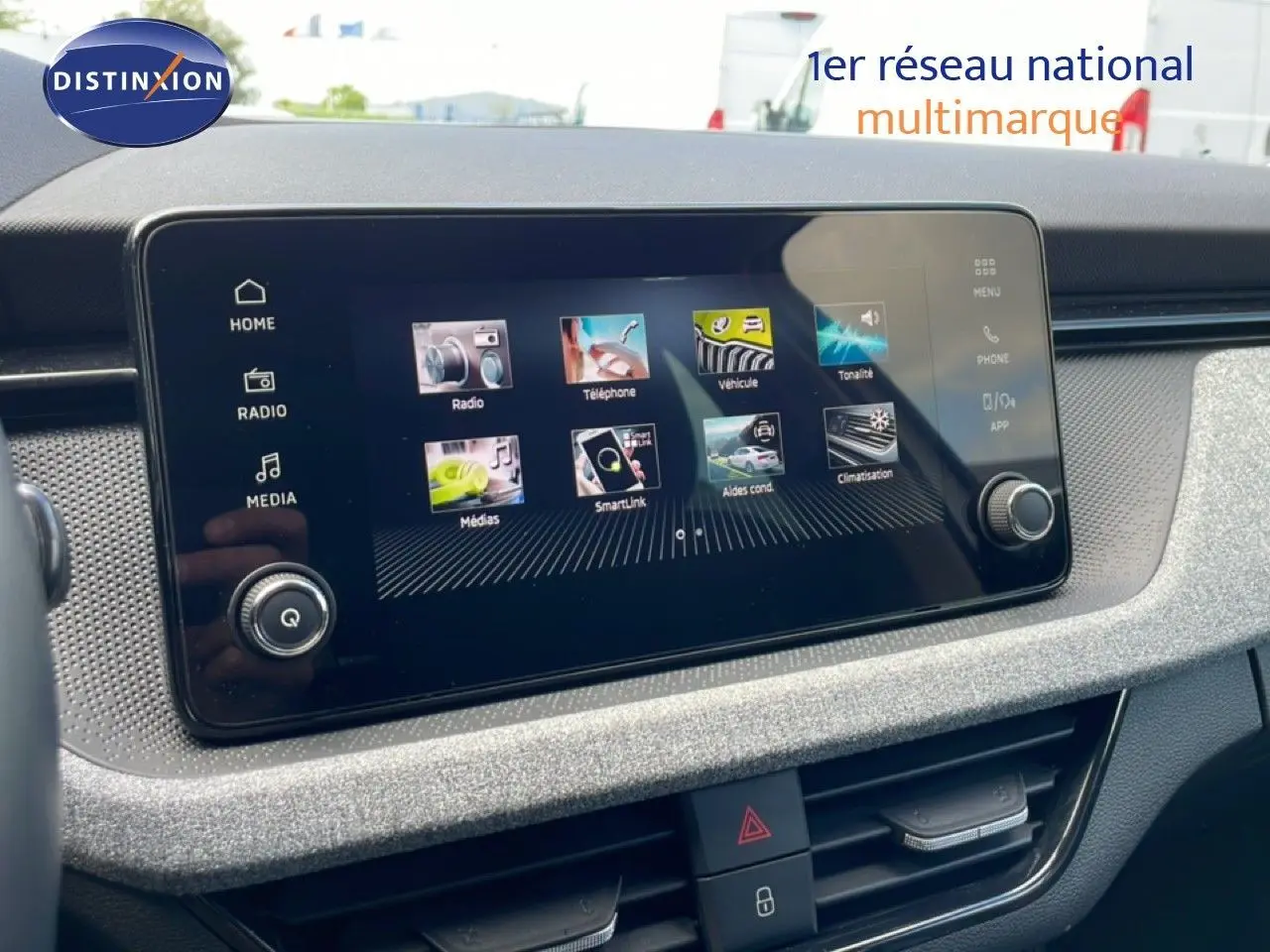 Écran tactile central de la Skoda Scala blanc glacier 2025, vue rapprochée du tableau de bord avec interface multimédia.