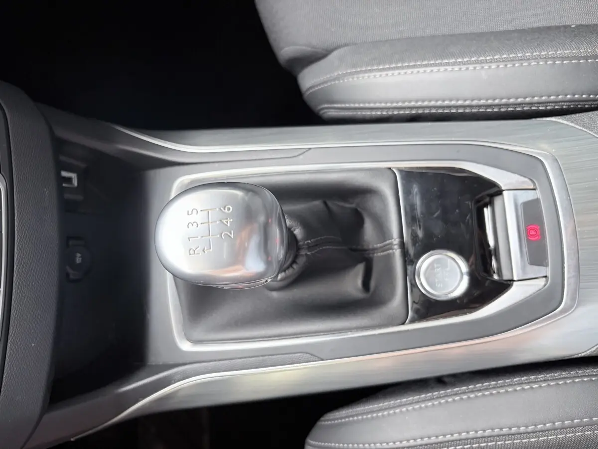 Gros plan sur le levier de vitesses manuel et bouton démarrage de la Peugeot 308 BlueHDi gris foncé, intérieur cuir noir.