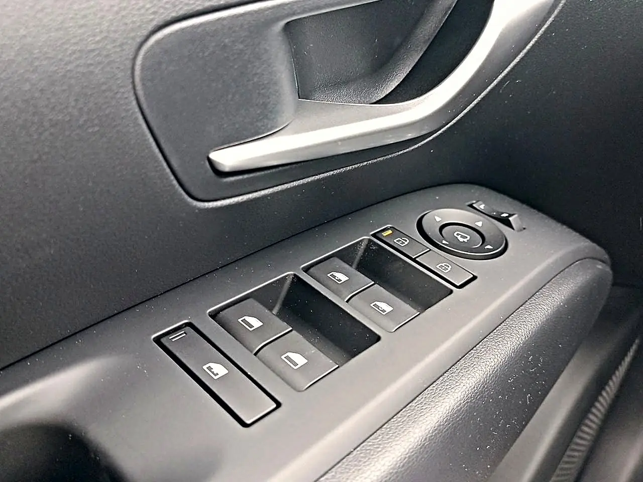 Gros plan sur les commandes de lève-vitres et rétroviseurs côté conducteur du Hyundai Tucson gris Ecotronique 2026.