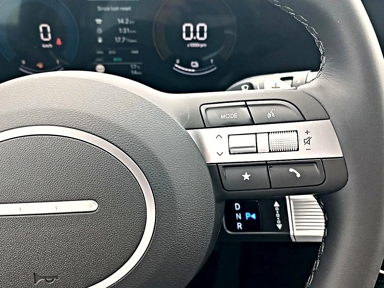 Gros plan sur le volant cuir multifonction du Hyundai Tucson 2026, avec commandes audio et levier de vitesses digital.
