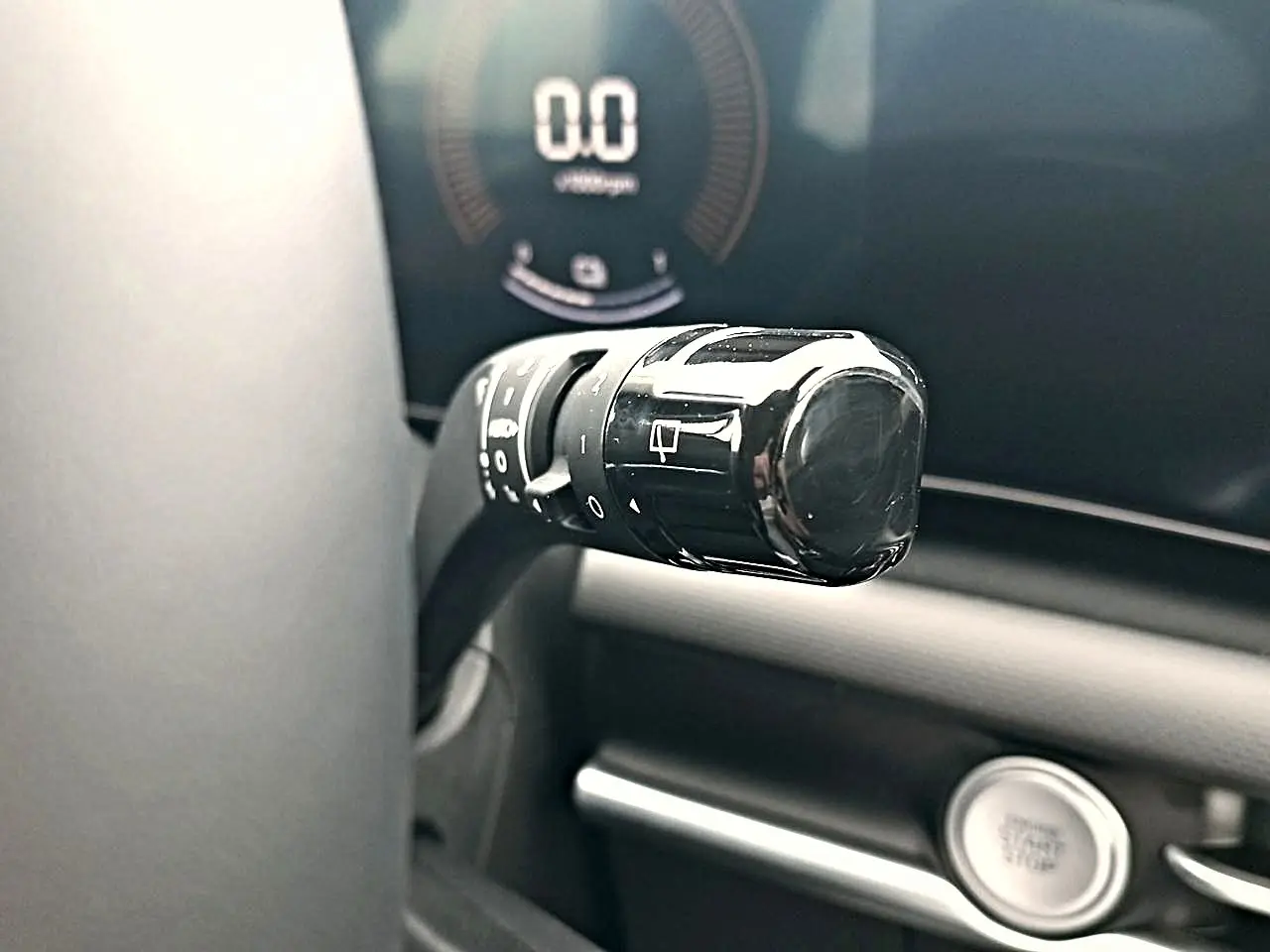 Gros plan sur la manette de commande noire à gauche du volant dans l’habitacle du Hyundai Tucson gris écotronique.