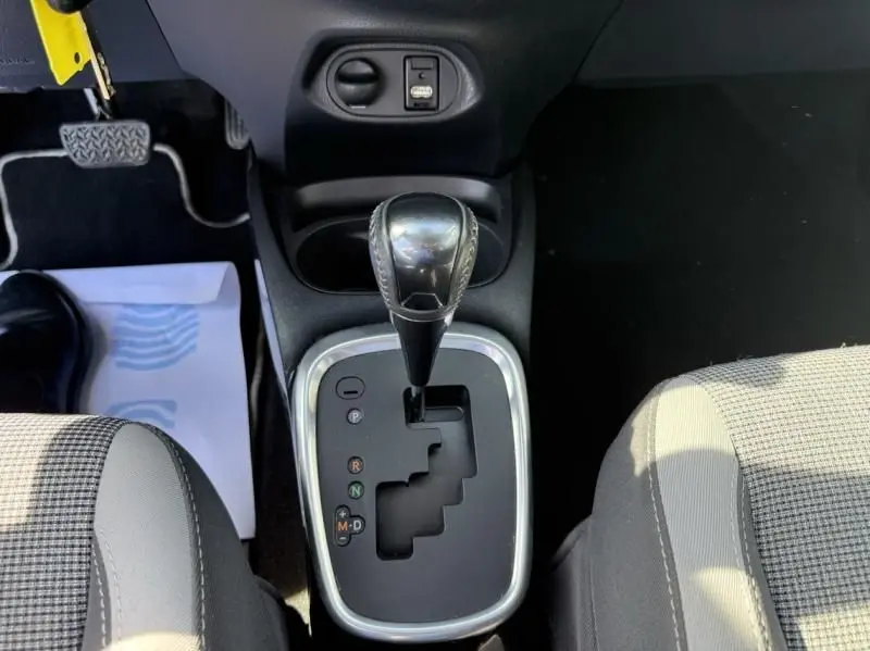 Vue rapprochée du levier de vitesses automatique de la Toyota Yaris 2020 gris métal, avec console centrale et sièges partiels visibles.