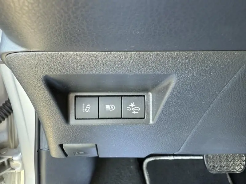 Détail des commandes d'assistance au conducteur sur le tableau de bord côté gauche d'une Toyota Yaris gris métal 2020.