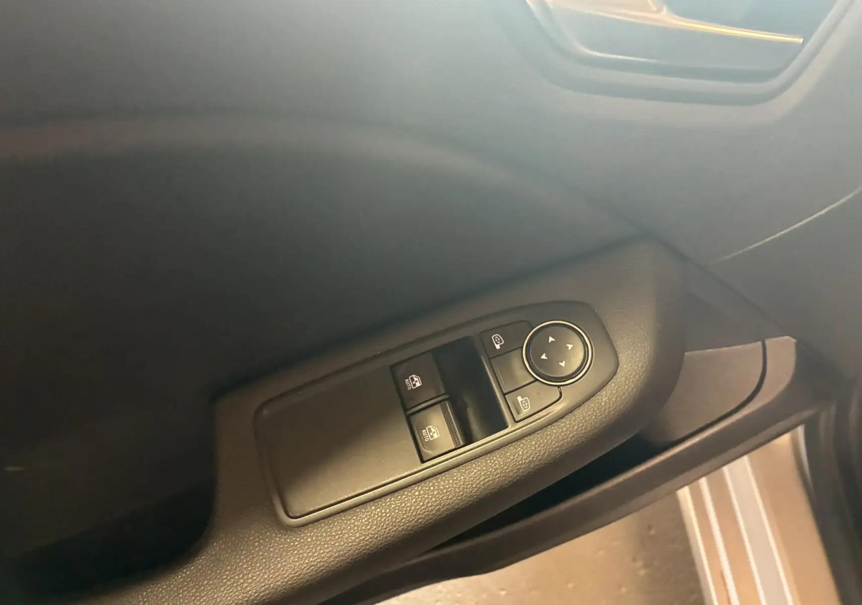 Vue rapprochée du panneau de commandes des vitres côté conducteur d'une Renault Clio 1.5 BlueDCI Business gris 2022.