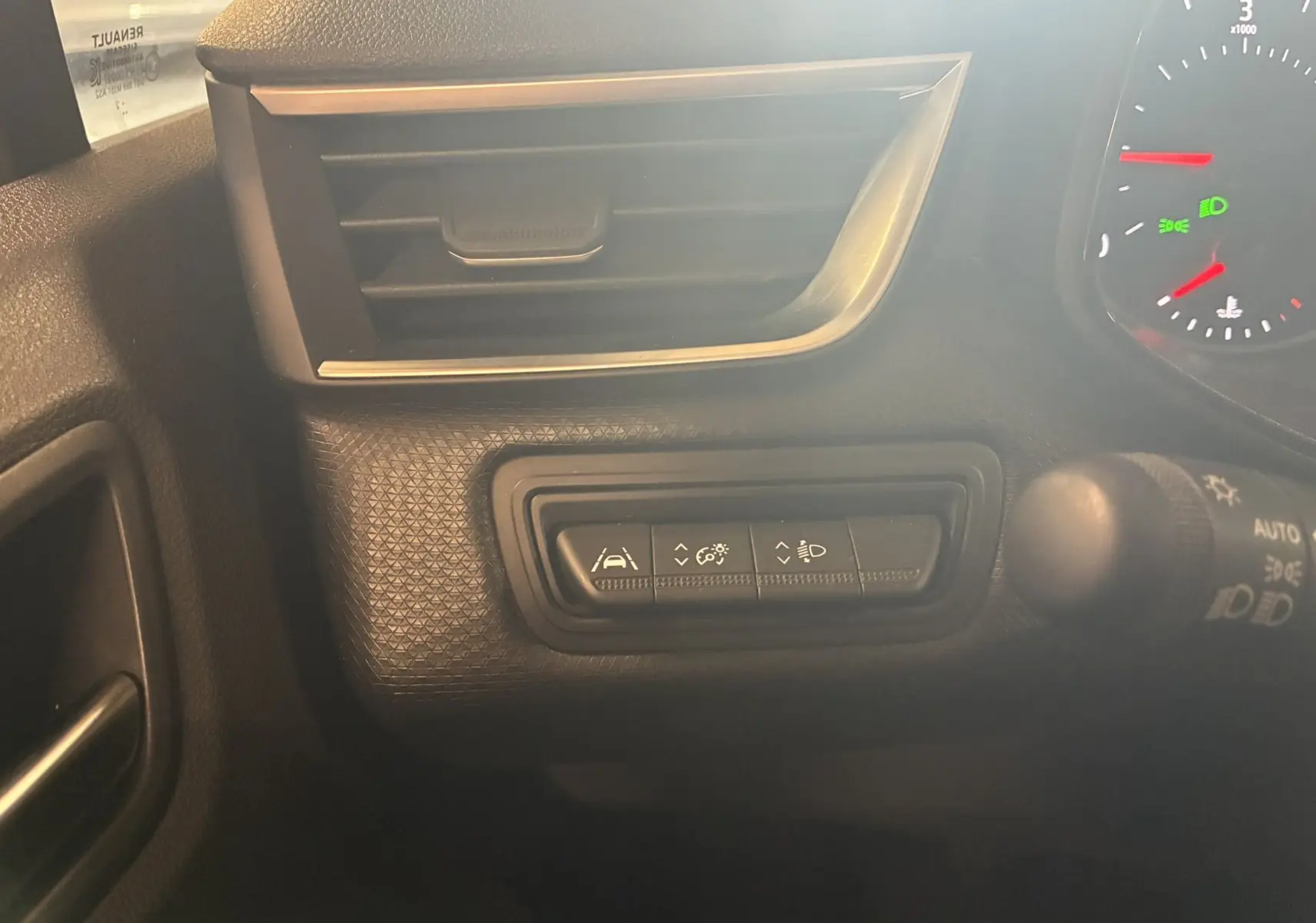 Vue intérieure du tableau de bord gris foncé de la Renault Clio 1.5 BlueDCI Business 2022, avec commandes d'assistance et ventilation.