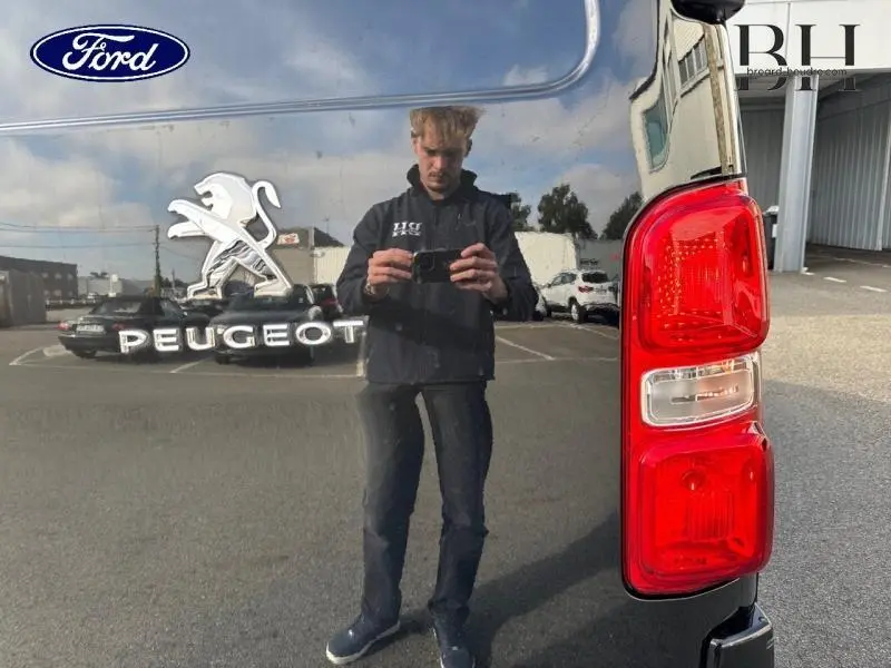 Gros plan sur le feu arrière droit et le logo Peugeot sur la carrosserie noire Perla Nera du fourgon Expert.