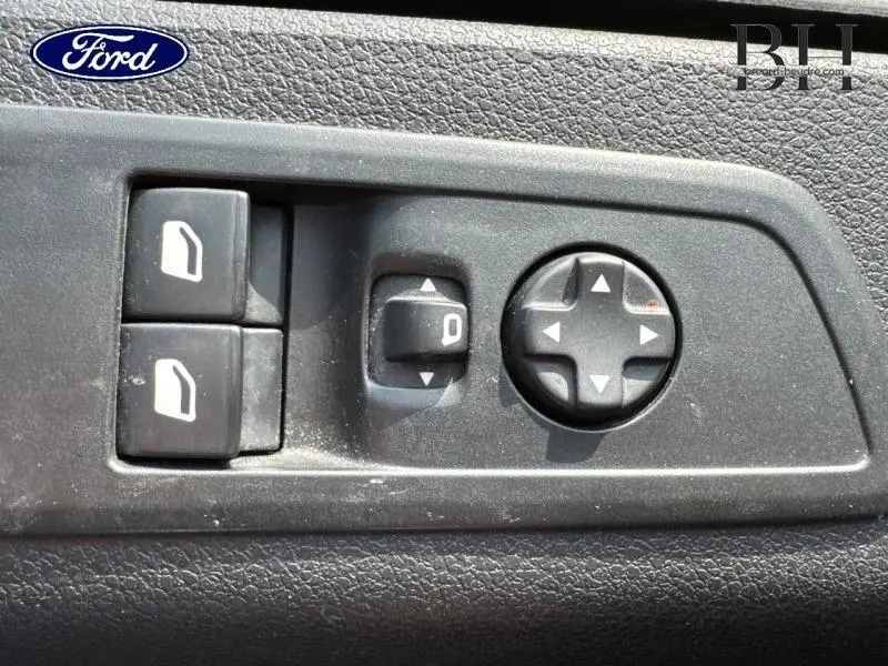 Gros plan sur les commandes de réglage des rétroviseurs électriques sur une porte intérieure noire du Peugeot Expert Fourgon 2022.