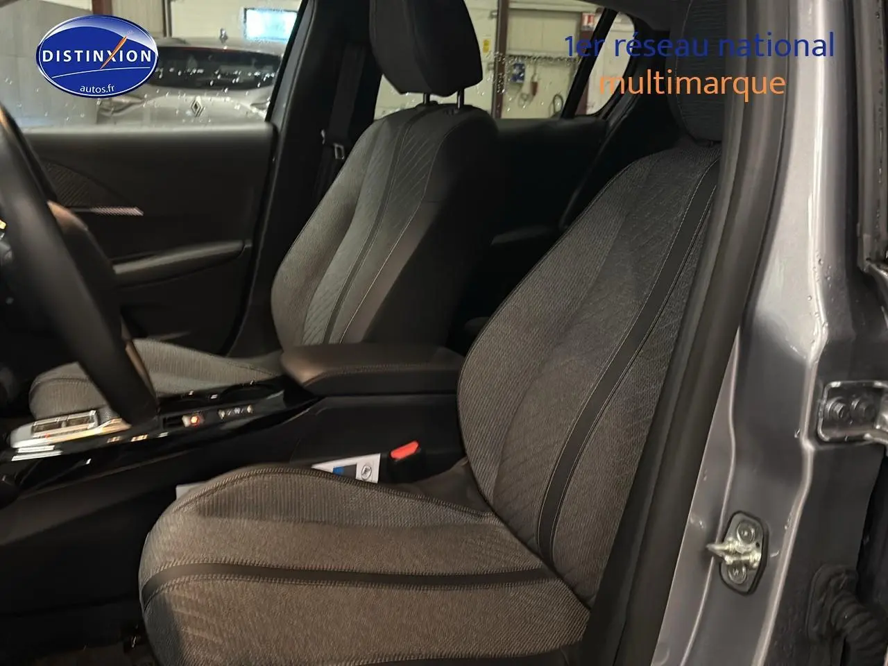 Vue intérieure côté gauche montrant les sièges avant gris d'une Peugeot 208 1.2 hybrid 110 allure e-dcs6 2025.