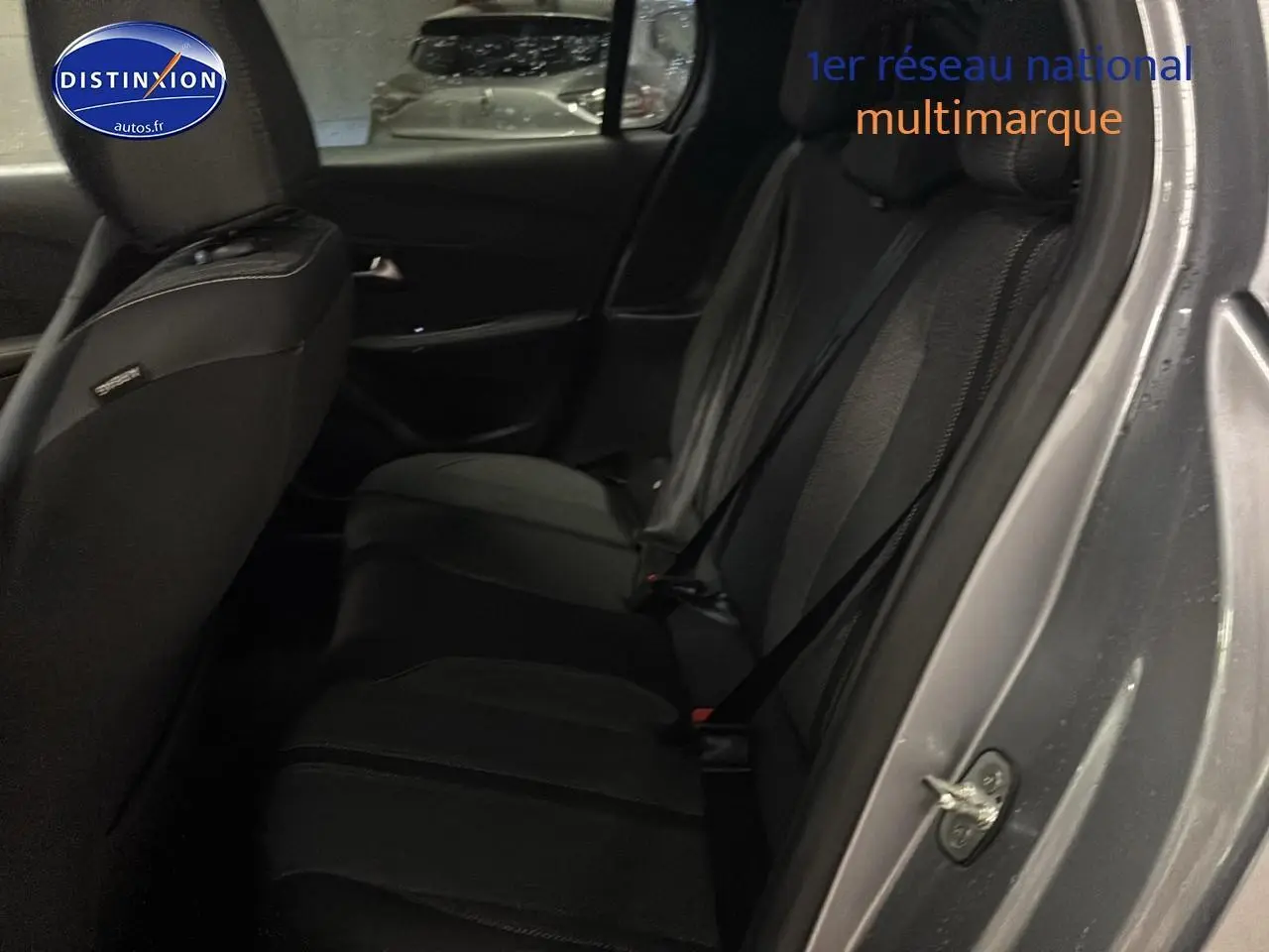 Vue intérieure côté droit montrant la banquette arrière noire d'une Peugeot 208 gris artense 2025.