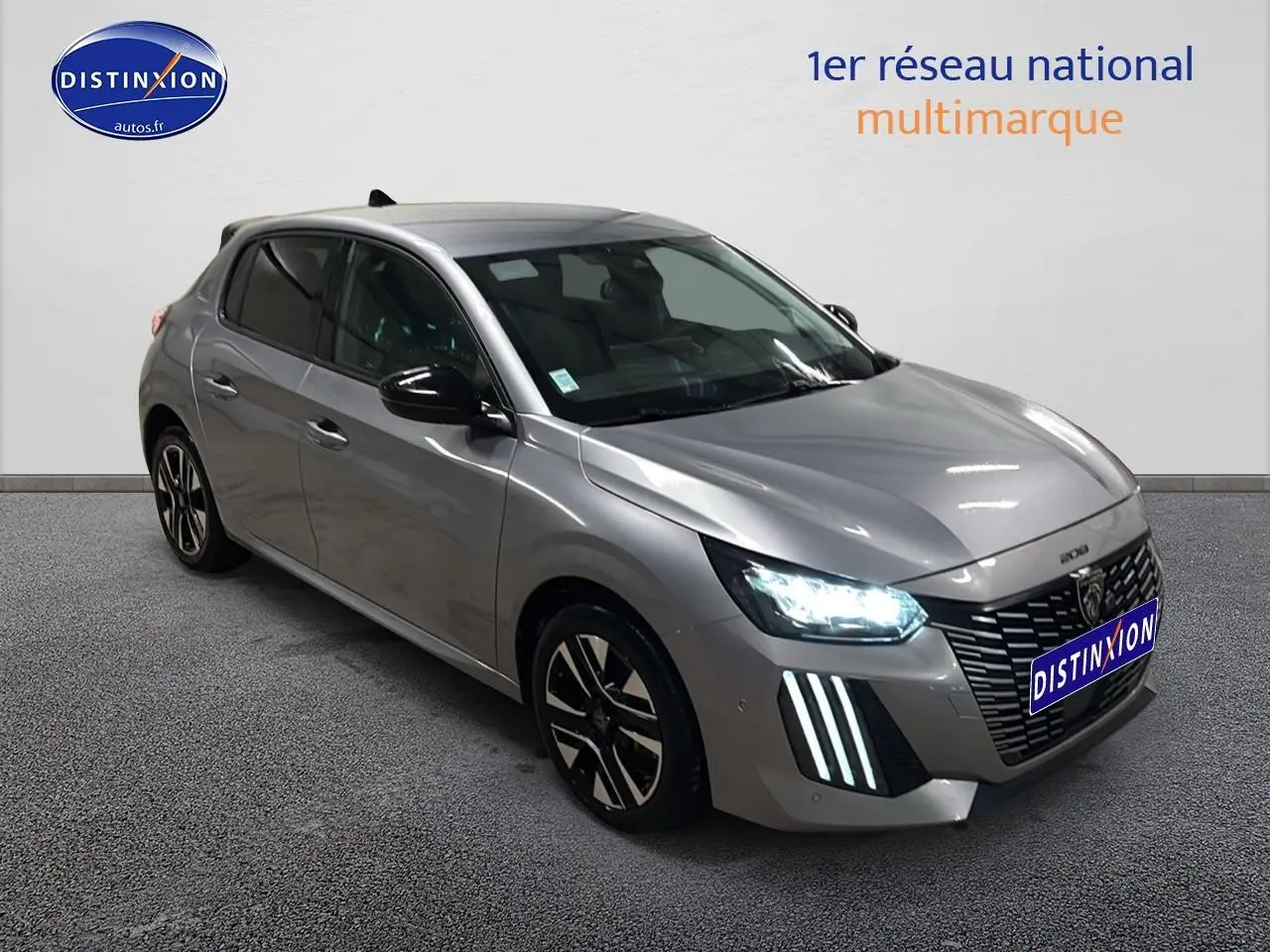 Peugeot 208 gris Artense en 3/4 avant droit avec phares LED allumés et jantes alliage noires.