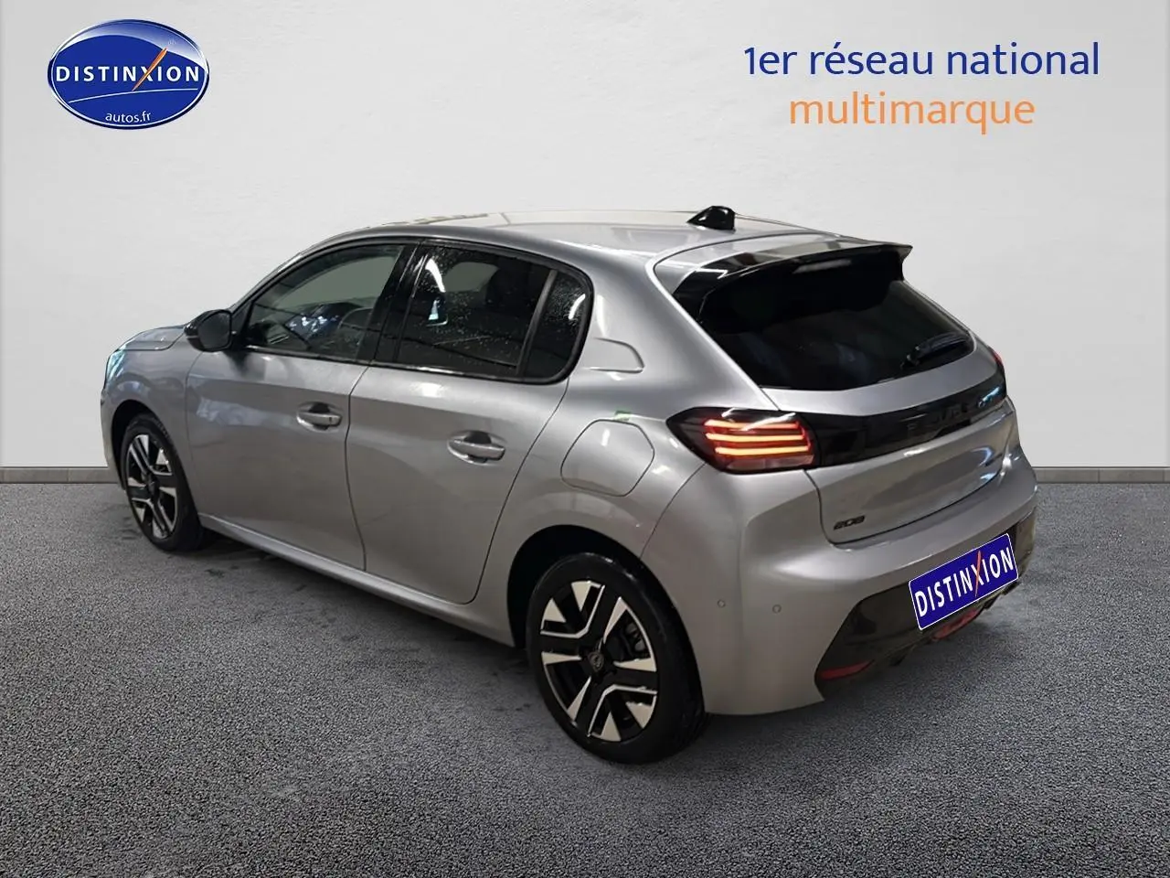 Vue 3/4 arrière droite d'une Peugeot 208 gris artense avec feux arrière LED allumés et jantes alliage.