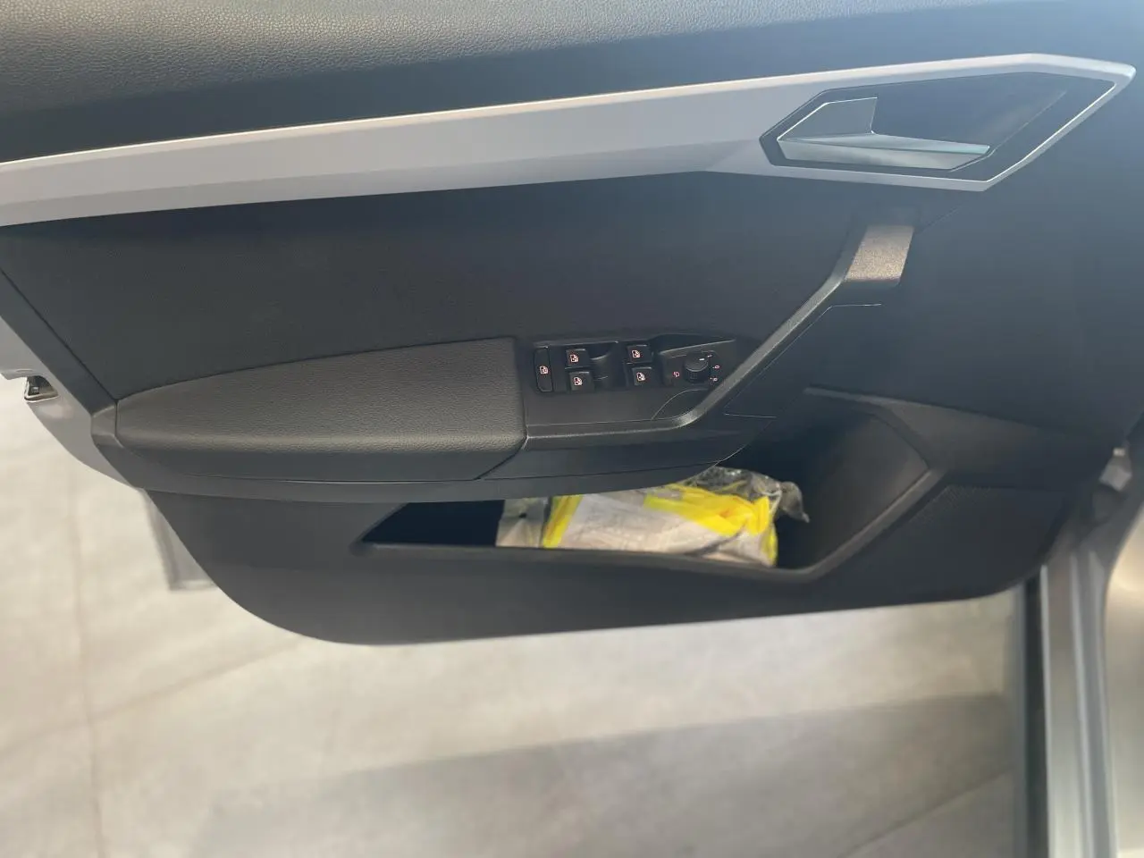 Vue rapprochée de la porte avant gauche de la SEAT Arona 2024, avec commandes de vitres et rangement intégré.