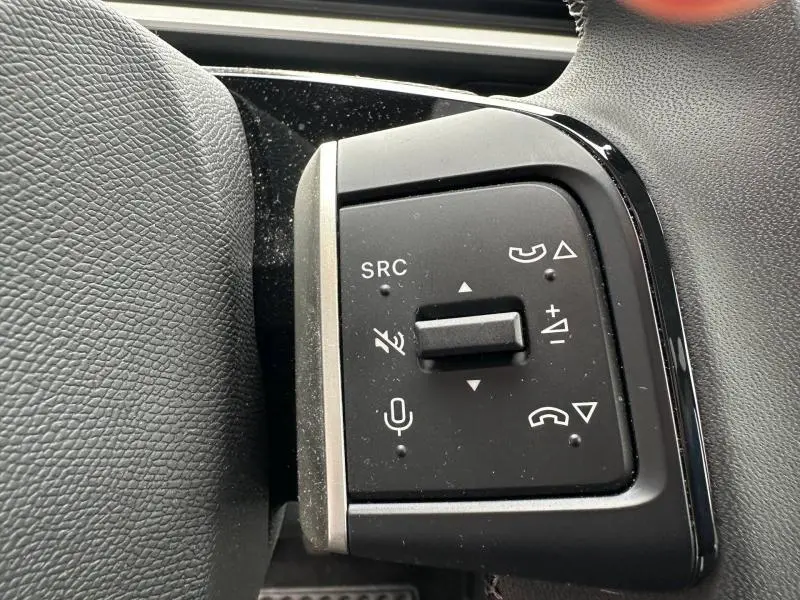 Gros plan sur les commandes multifonctions noires au volant du Citroën C3 1.2 Turbo 100ch MAX, intérieur gris.