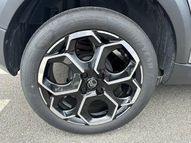 Gros plan sur la roue avant droite d'une Citroën C3 2025 Gris Mercury avec jante noire et argentée au design hexagonal.