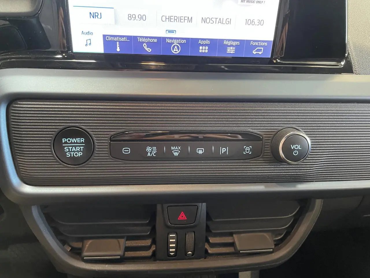 Tableau de bord du Ford Tourneo Courier 2024 avec écran tactile, bouton start/stop et commandes climatisation intégrées.