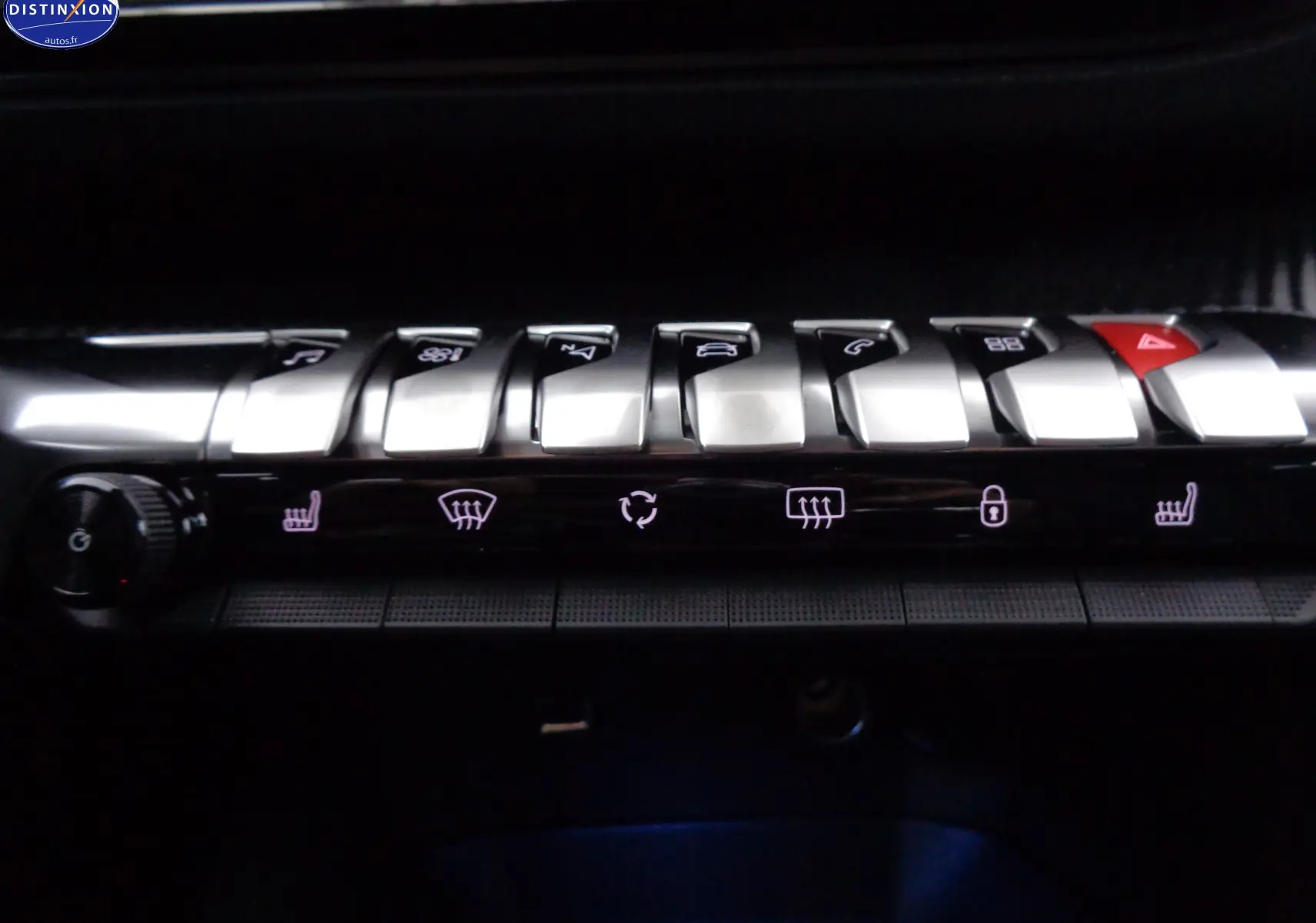 Gros plan sur la rangée de boutons argentés du tableau de bord du Peugeot 3008 noir perle 2023, avec commandes clim et alertes.