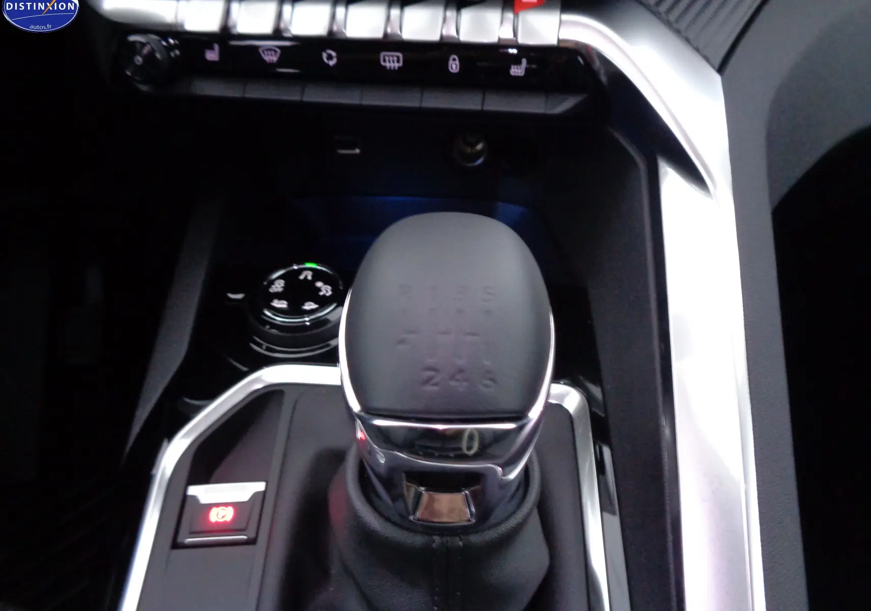 Gros plan sur le levier de vitesse automatique et les commandes du tableau central d'un Peugeot 3008 noir perle métal.