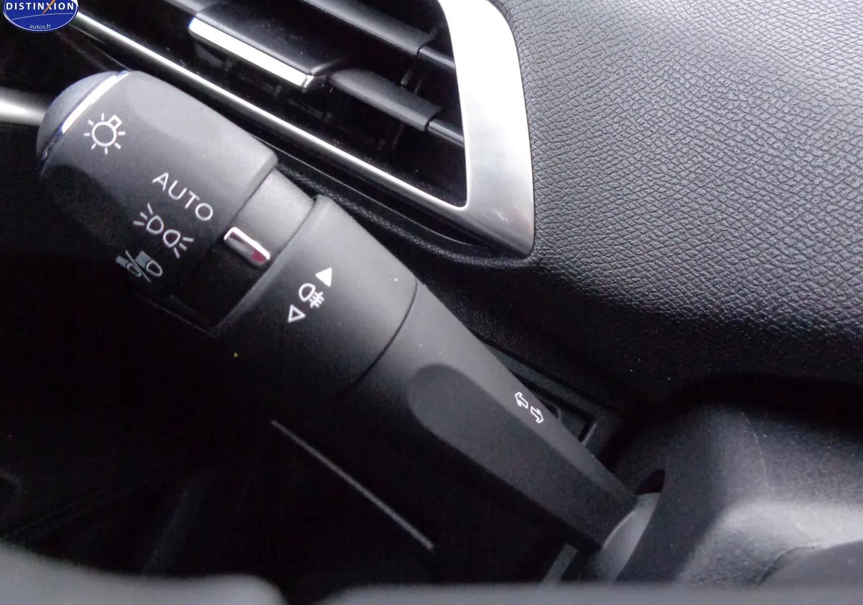 Gros plan sur la commande des feux et clignotants dans l'habitacle noir du Peugeot 3008 2023.