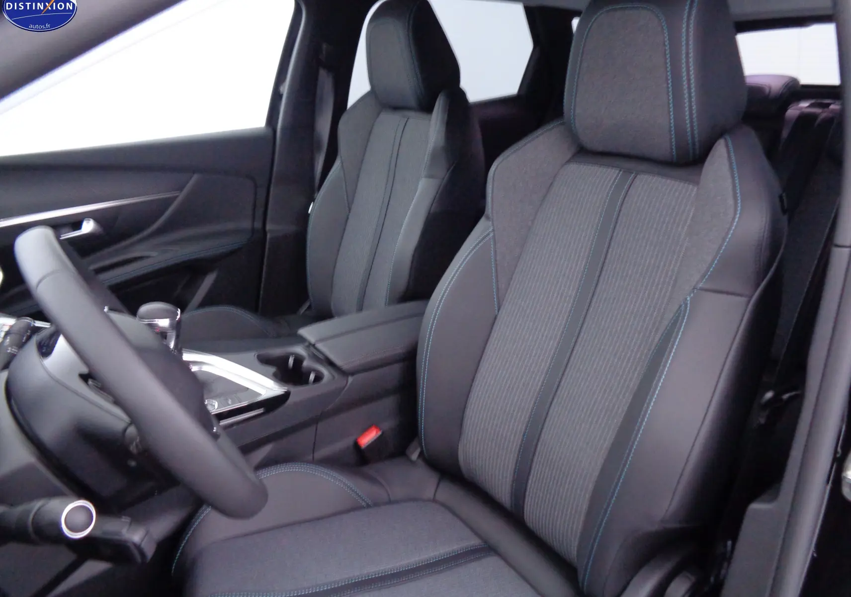 Intérieur Peugeot 3008 2023 en vue côté conducteur, sièges tissu et cuir noir avec surpiqûres bleues.