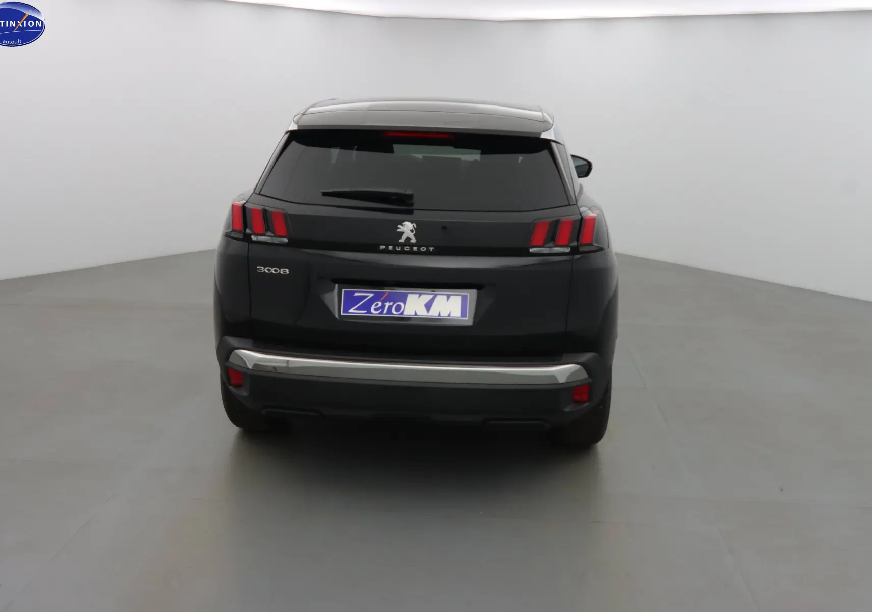 Vue arrière d'un Peugeot 3008 noir perle métal 2023 avec feux arrière à griffes et plaque Zero KM.