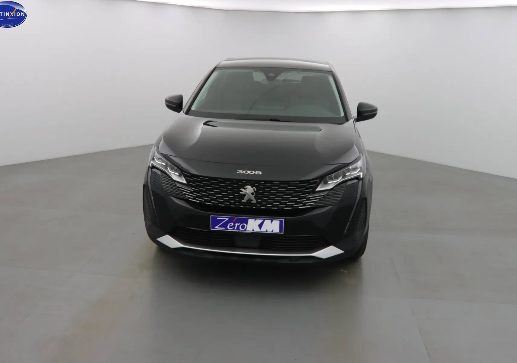 Peugeot 3008 noir perle métal vue de face dans un studio, avec calandre distinctive et phares LED allumés.