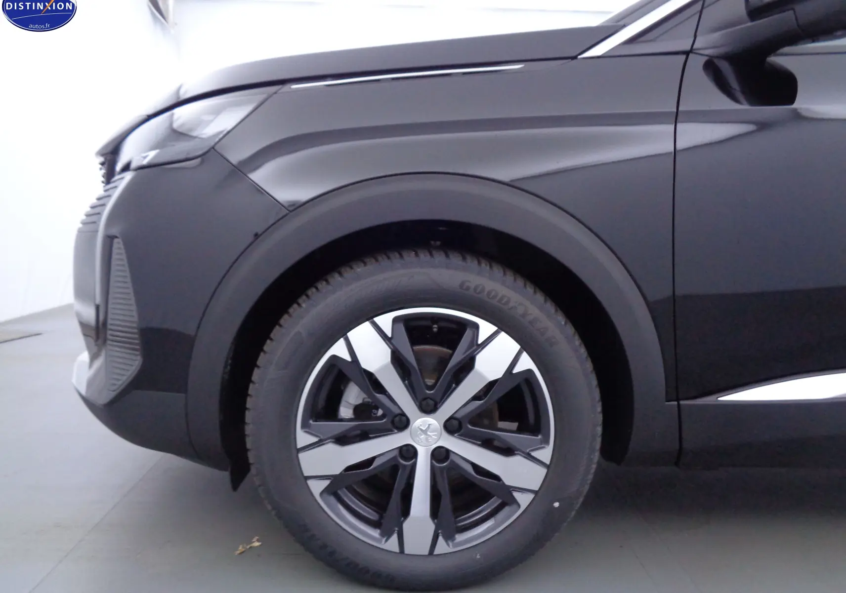 Gros plan sur la roue avant gauche et l'aile d'une Peugeot 3008 noir perle métal vue de profil.