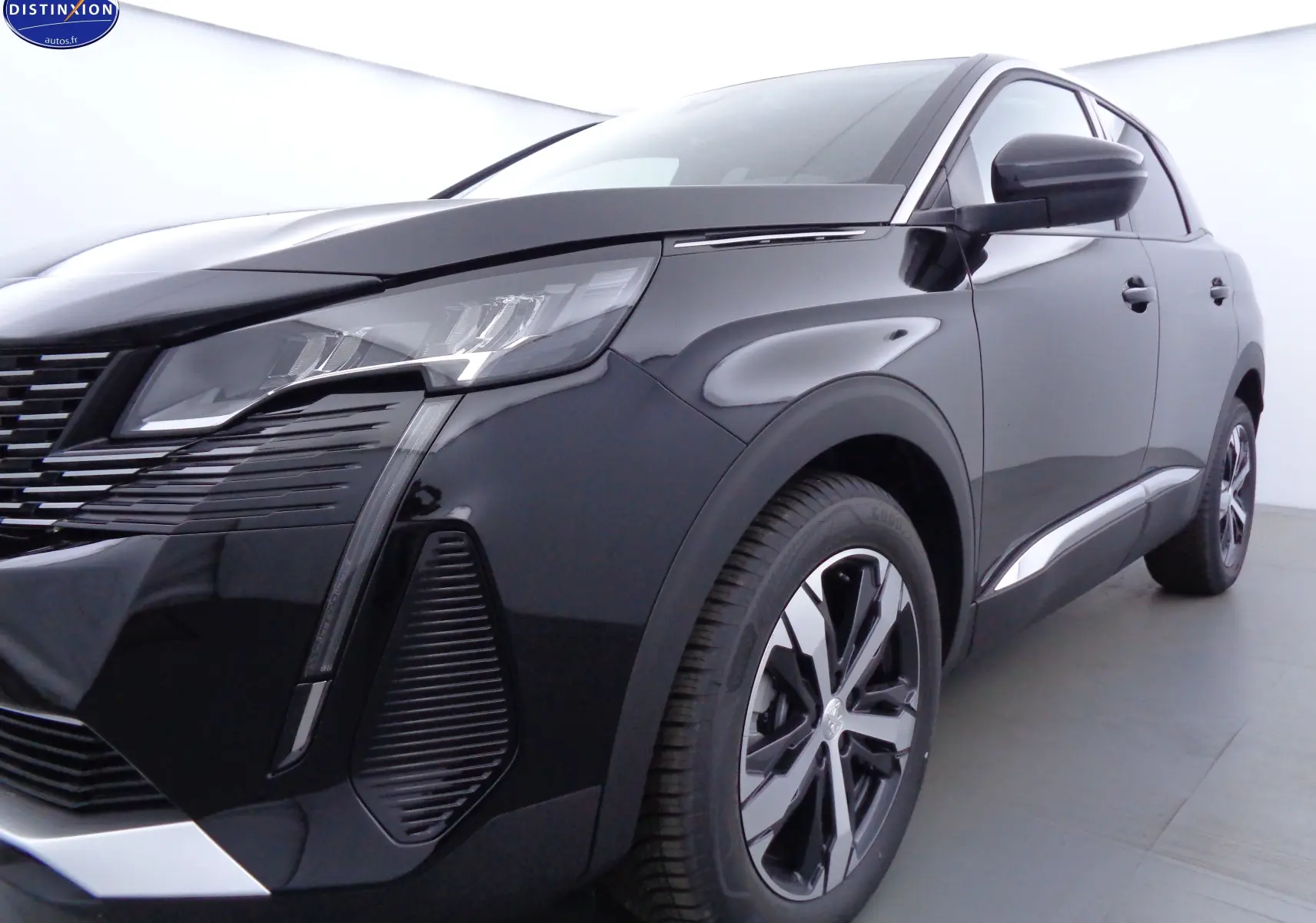 Vue 3/4 avant droit du Peugeot 3008 noir perle métal 2023 avec ses phares LED et jantes bi-ton distinctives.