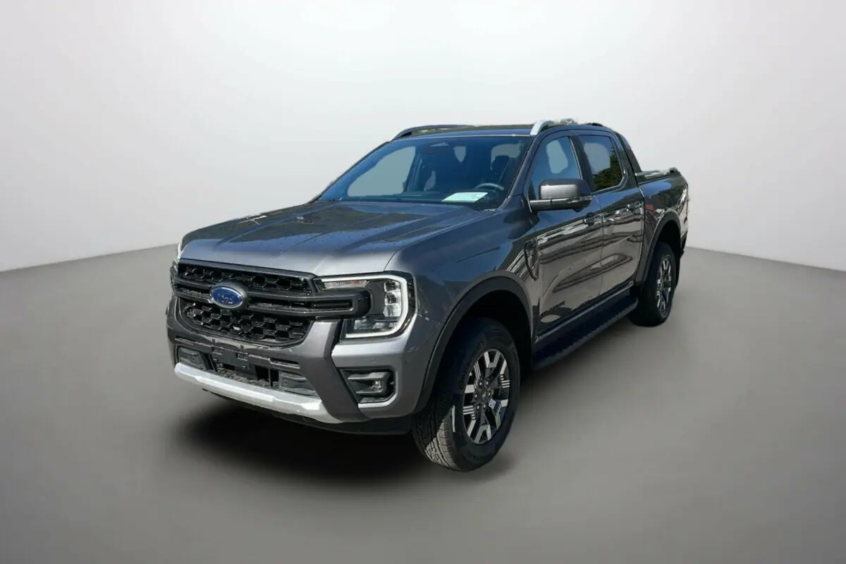 Ford Ranger 2025 gris carbone en vue 3/4 avant droit, avec calandre imposante et jantes alliage distinctives Wildtrak Plus.