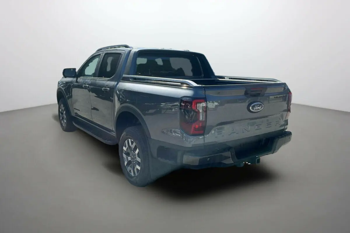 Ford Ranger 2.3 PHEV Wildtrak Plus gris carbone vu en 3/4 arrière droit avec benne et jantes alliage.