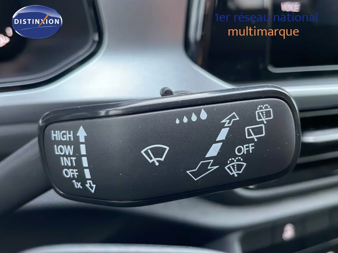 Gros plan sur la commande d’essuie-glace intérieur du Volkswagen T-Roc noir Grenadilla métal, avec pictogrammes blancs visibles.