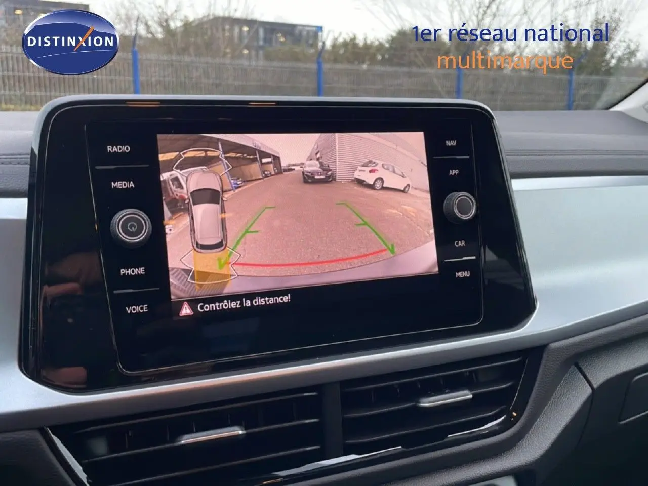 Vue intérieure sur l’écran de la caméra de recul du Volkswagen T-Roc noir Grenadilla, avec affichage des aides au stationnement.