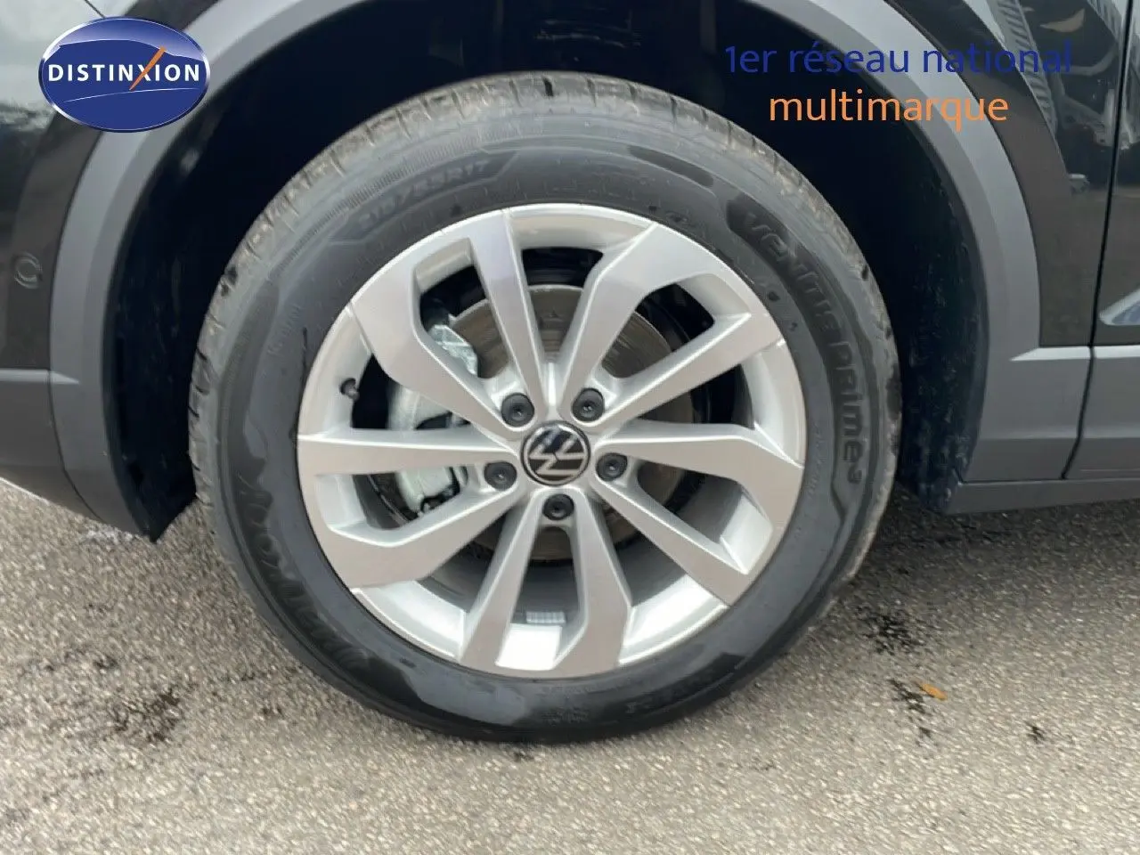 Gros plan sur la roue avant gauche d’un Volkswagen T-Roc noir Grenadilla Metal avec jante alliage 17 pouces.