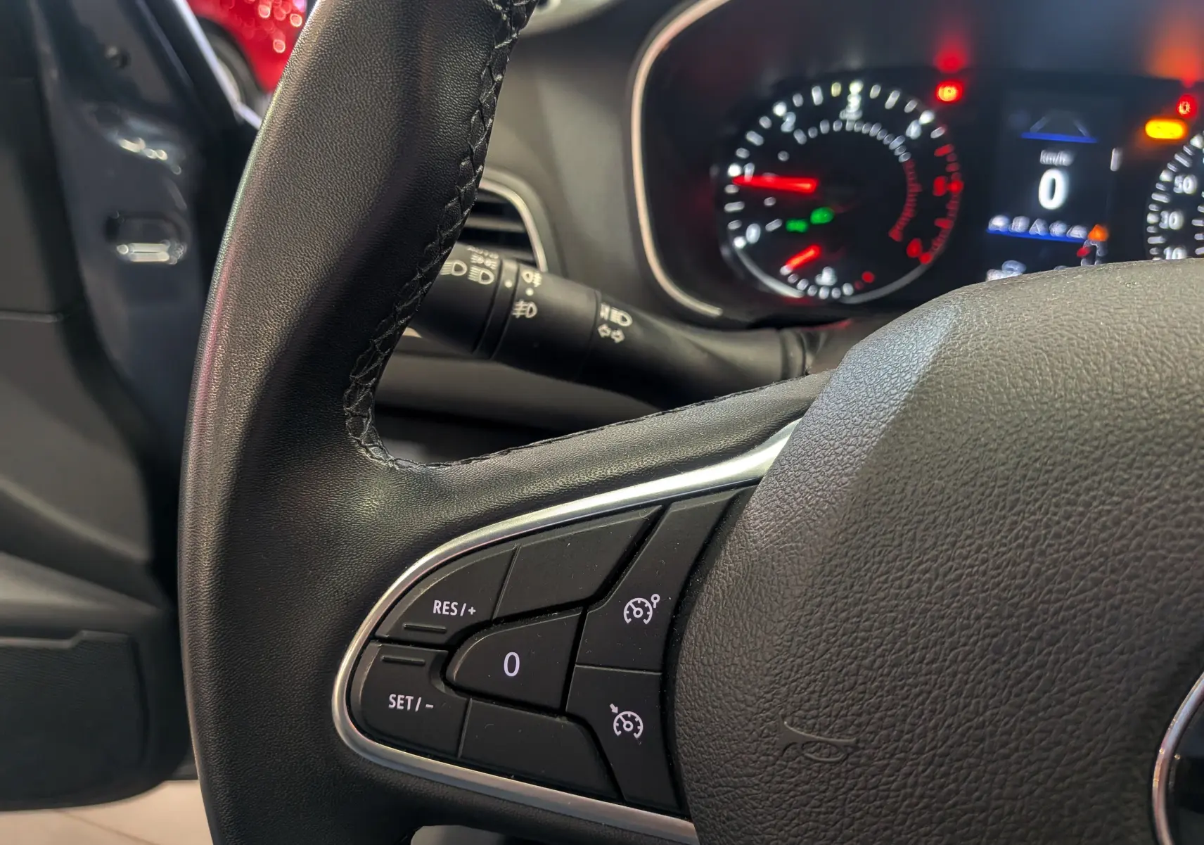 Gros plan sur le volant de la Renault Mégane IV Berline 2022, montrant les commandes de régulateur de vitesse.