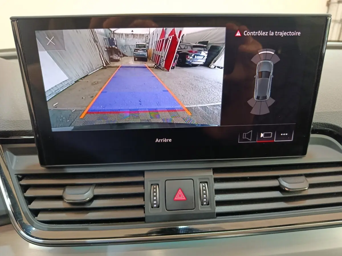 Écran intérieur de l’Audi Q5 2023 gris clair montrant la caméra de recul avec guidage de trajectoire.